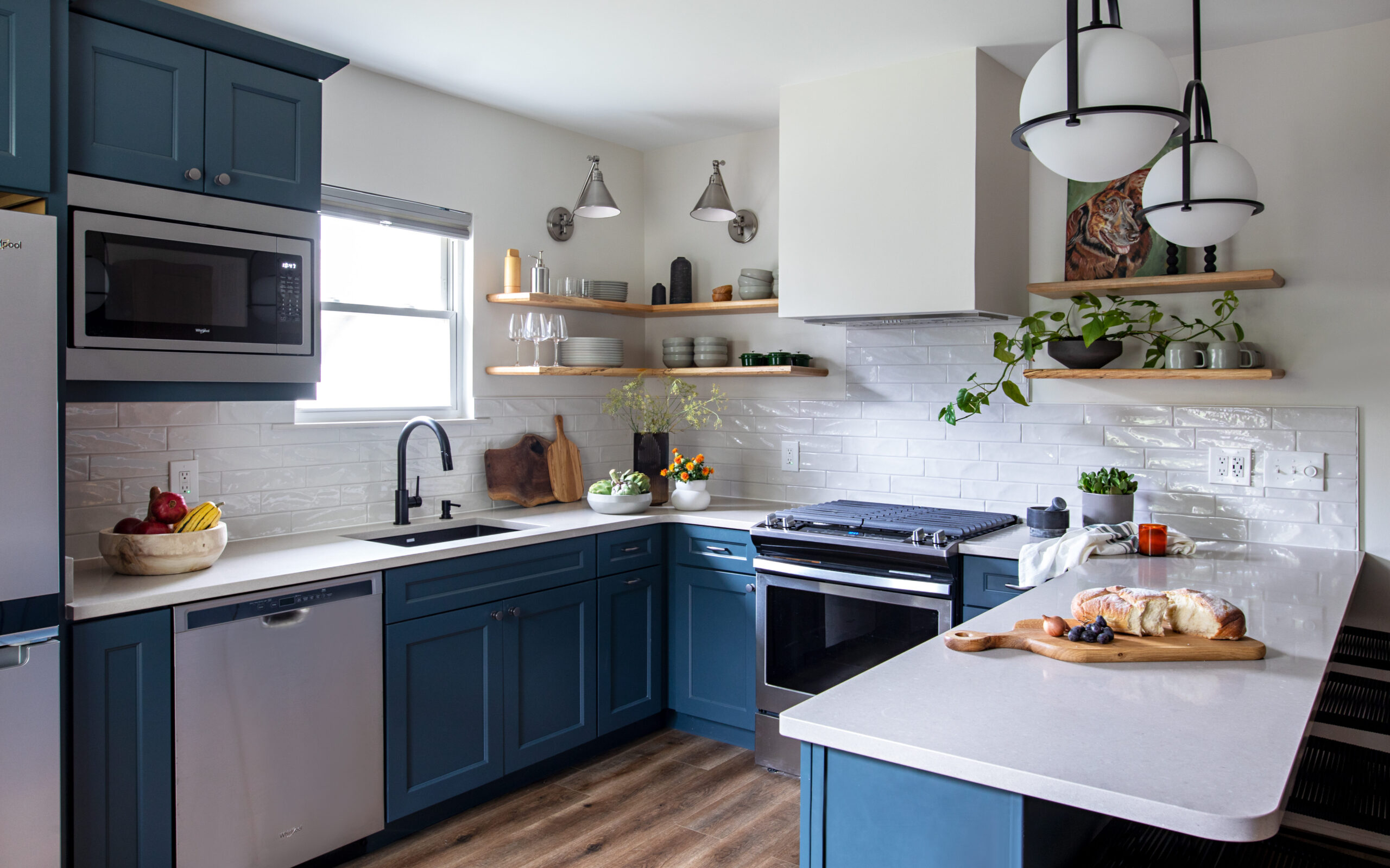 Kitchen with blue painted cabinets and wood flooring.